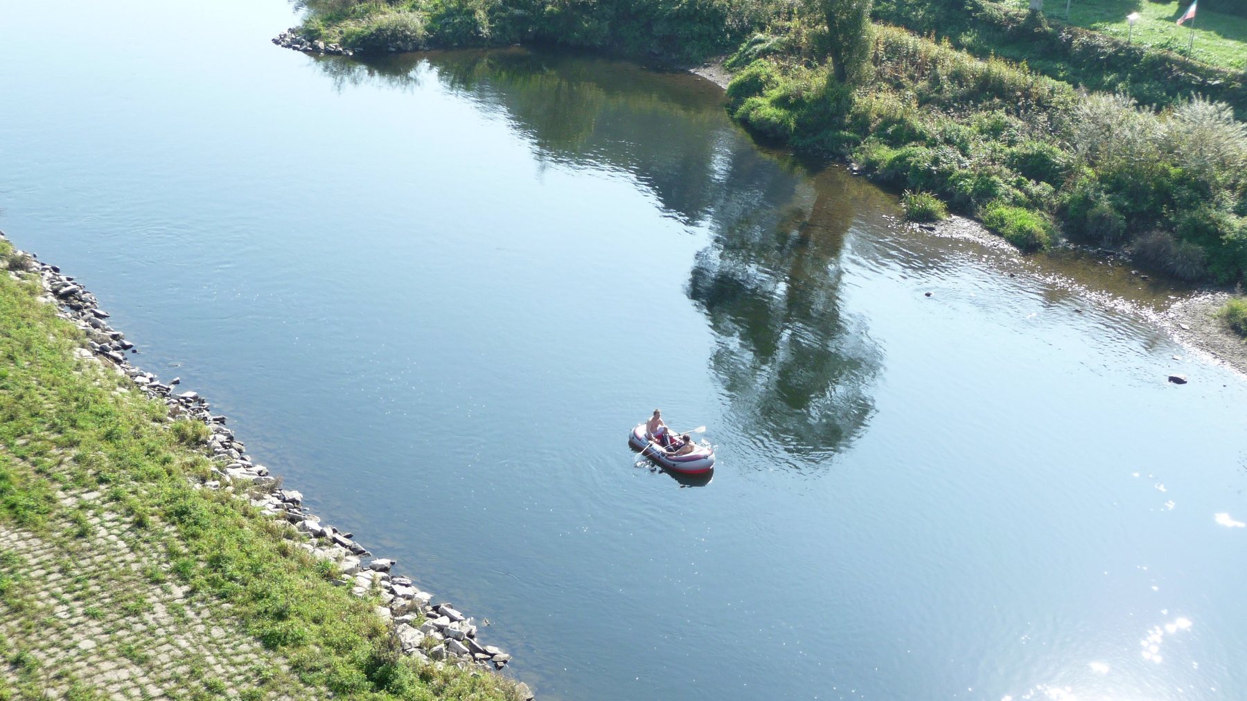 Blick von oben auf einen Fluss mit Schlauchboot